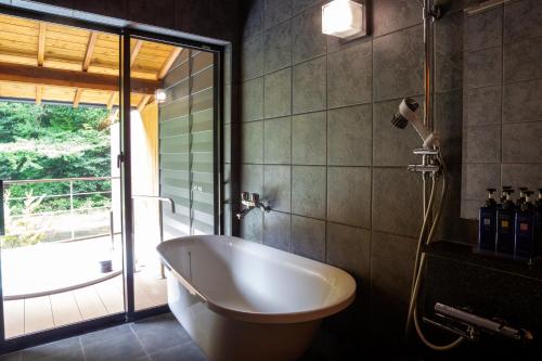 a bathroom with a bath tub and a shower at Tsukiyominoza in Ise