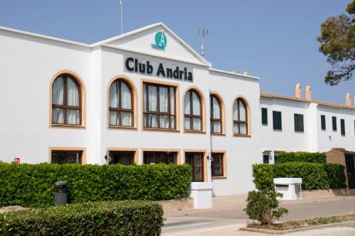 un edificio bianco con un cartello che legge club antico di Grupoandria Aparthotel Club Andria a Cala Santandria