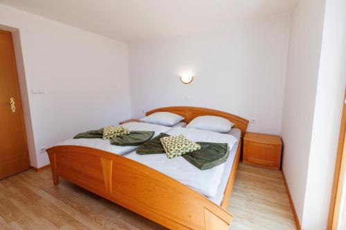 - une chambre avec un lit en bois et 2 oreillers dans l'établissement Apartmaji pr` Brdarju, à Bohinj