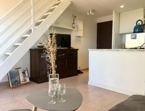 - un salon avec une table et 2 verres à vin dans l'établissement 9 - Agréable appartement, terrasse, vue mer et parking, à Bandol