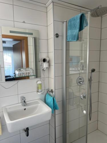 a bathroom with a sink and a shower at Hotel Restaurant Bürgerstuben in Altenstadt