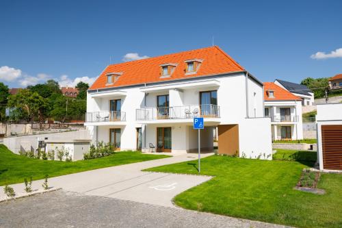 a white house with an orange roof at Hotel Historia Malomkert in Veszprém