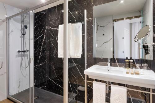 a bathroom with a sink and a shower at Exe Sevilla Macarena in Seville