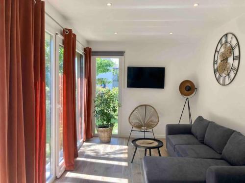 uma sala de estar com um sofá e uma televisão em Maison neuve à deux pas du Mont em Beauvoir