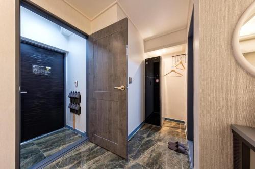 um corredor com uma porta de madeira e um corredor com uma janela em Ballantine Business Hotel em Gwangju