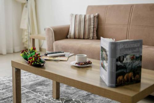 a coffee table with a book and a cup of coffee at BOOK ME! 3 BR Apartment Beach Front (Side View) in Abu Dhabi