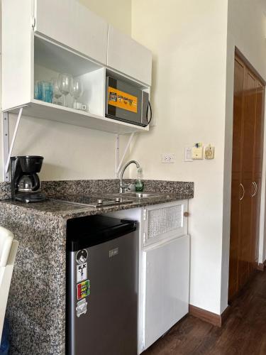 a kitchen with a black refrigerator and a counter at Hotel Palmera Bayahibe in Bayahibe