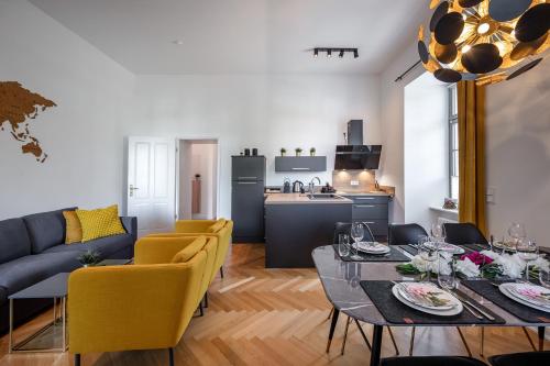 a living room with a table and yellow chairs and a kitchen at Acapella Suite Allegro 76qm I Altstadt l Weinberg in Heppenheim an der Bergstrasse