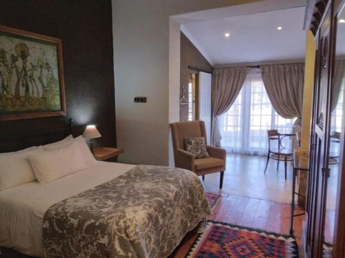 een hotelkamer met een bed en een stoel bij VULTURES LODGE in Zastron