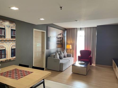 ein Wohnzimmer mit einem Sofa und einem Tisch in der Unterkunft The Straits Hotel & Suites in Malakka