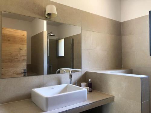 une salle de bain avec un lavabo blanc et un miroir dans l'établissement Villa de standing et vue mer Porto Vecchio, à Porto-Vecchio