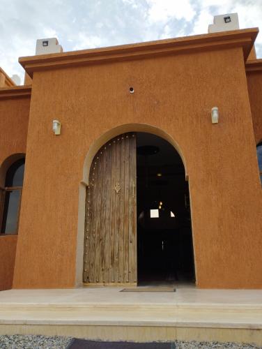 a brown building with a wooden door on it at DAR AL QANASS IMANE in Midelt