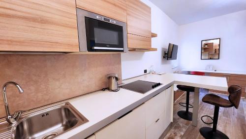 cocina con fregadero y encimera con 2 sillas en Appartamenti Museo, en Verona