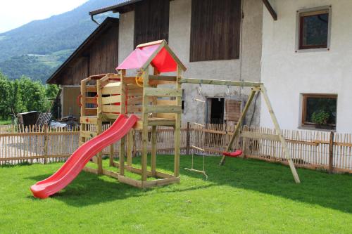 a playground in a yard with a slide and a swing at Gartnerhof in Plaus