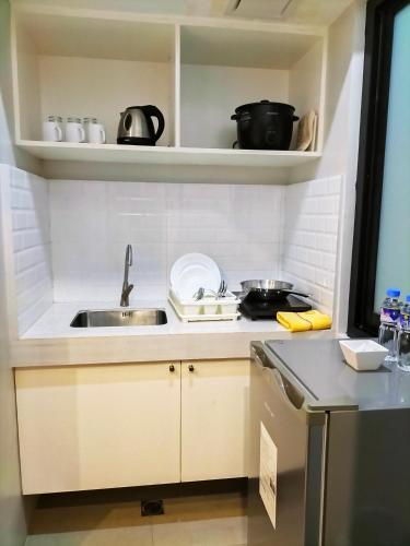 a small kitchen with a sink and a stove at Dachannry's Place Hotel in Cagayan de Oro