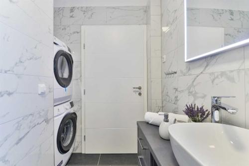 a bathroom with a washing machine and a sink at Luxury Stone Villa BANOVI with heated pool in Vinjerac