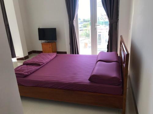 a bedroom with a purple bed and a window at Homestay Hoài Tâm Phan Thiết in Phan Thiet
