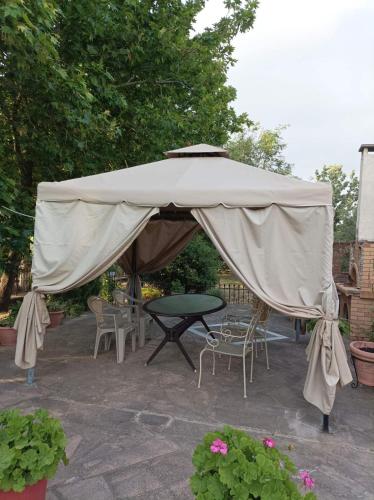 a large tan umbrella on a patio with chairs and tables at Mountain Voyage Residences in Vatoússa