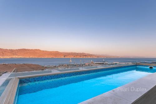 a swimming pool with a view of the water at YalaRent Mountainside Duplexes with Private Pool in Eilat