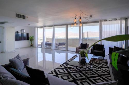 una sala de estar con un sofá y una mesa en YalaRent Mountainside Duplexes with Private Pool, en Eilat