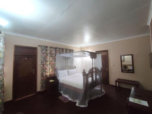 a bedroom with a bed with a canopy at LUSHOTO EXECUTIVE LODGE in Lushoto