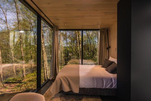 ein Schlafzimmer mit einem Bett und einem großen Fenster in der Unterkunft The Valley x Wilsum in Wilsum