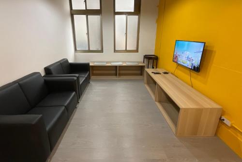 une salle d'attente avec des canapés et une télévision à écran plat dans l'établissement 星空間 Star co-living space, à Taipei