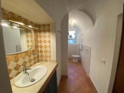 y baño con lavabo, espejo y aseo. en Lunigiana Experience en Pontremoli