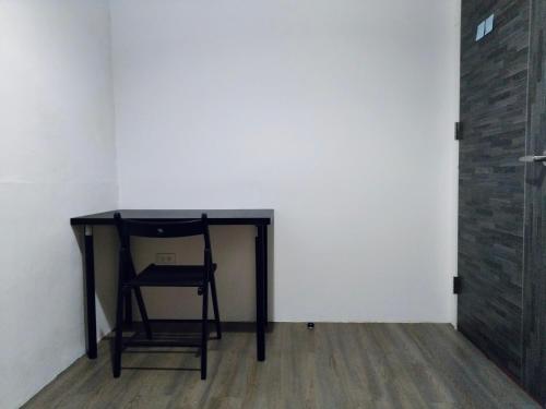 a black desk with a chair next to a wall at PURE st-ay in Taipei