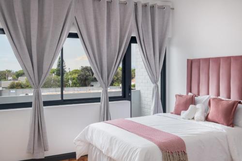 a bedroom with a bed and a large window at Rest on Millvale guest house in Cape Town