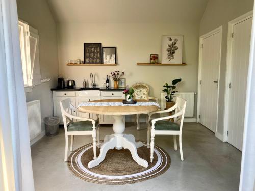 uma cozinha com mesa e cadeiras num quarto em Huisje aan ‘t Hof em Bronkhorst