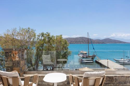 a balcony with chairs and a view of the water at Naiades Boutique Hotel - Adults Only in Elounda
