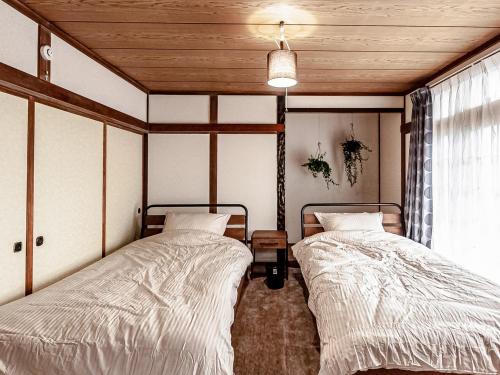2 Betten in einem Zimmer mit Holzdecken in der Unterkunft LOL - Vacation STAY 34627v in Hakodate