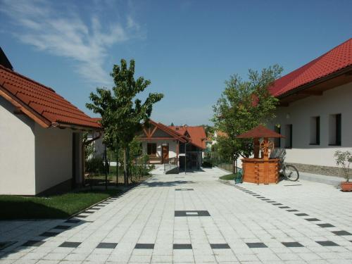einen Backsteinsteg zwischen zwei Gebäuden mit Bäumen in der Ferne in der Unterkunft Penzion Karen in Podhájska