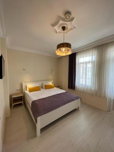 西代的住宿－維多利亞公主公寓式酒店，一间卧室配有一张床和一个吊灯