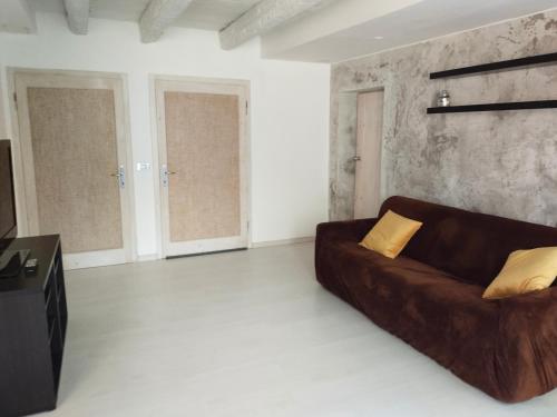 a living room with a brown couch and a tv at Casa vacanze Tredis in Nogaredo di Prato