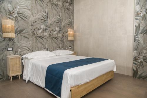 a bedroom with a bed with a floral wallpaper at suite 18 luxury apartments in Bari
