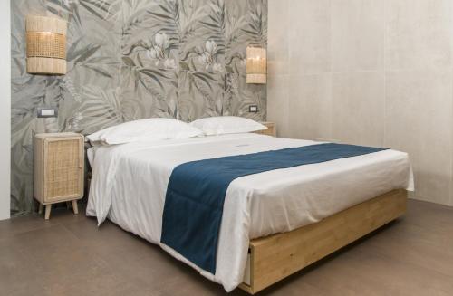 a bedroom with a large bed with a blue blanket at suite 18 luxury apartments in Bari