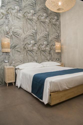 a bedroom with a bed with a floral wallpaper at suite 18 luxury apartments in Bari