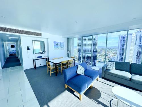 a living room with a blue couch and a table at LUXURY APARTMENT- with WATER VIEWS FROM EVERY DIRECTION in Gold Coast