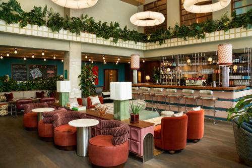 a lobby with tables and chairs and a bar at The Hoxton, Brussels in Brussels