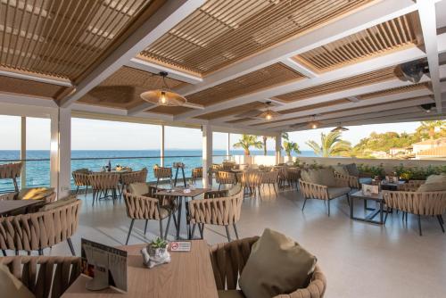 a restaurant with a view of the ocean at Anemona Beach Hotel in Argasi