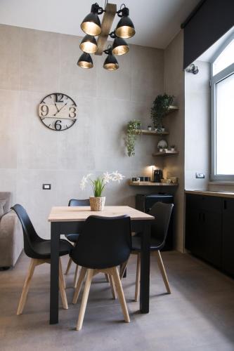 a dining room with a table and chairs and a clock at suite 18 luxury apartments in Bari