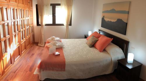 1 dormitorio con 1 cama con almohadas de color naranja en Canarifornia, en Telde