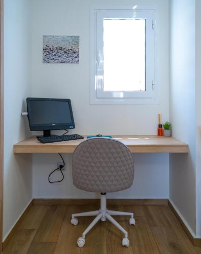 a desk with a computer and a chair in a room at Maxblue 2 in Piraeus