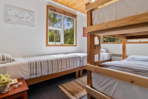 1 dormitorio con 2 literas y ventana en Mandala Bruny Island en Alonnah