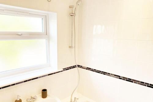 a bathroom with a shower and a sink and a window at Bristol House FREE Parking & Airport & M1 & Contractor in Luton