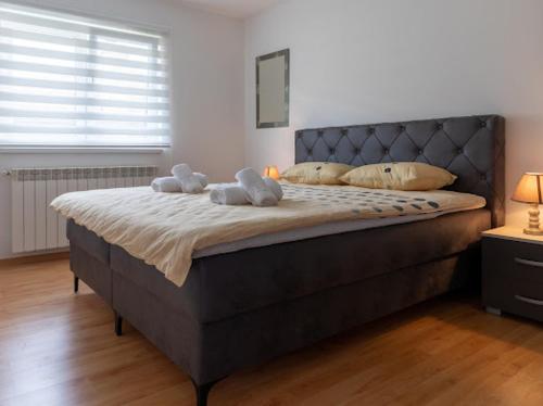 Un dormitorio con una cama con dos animales de peluche encima. en Apartmani BA, en Sarajevo