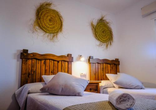 埃爾帕爾馬的住宿－Casas Dibaca by El Palmar，卧室配有两张床,墙上有两个篮子
