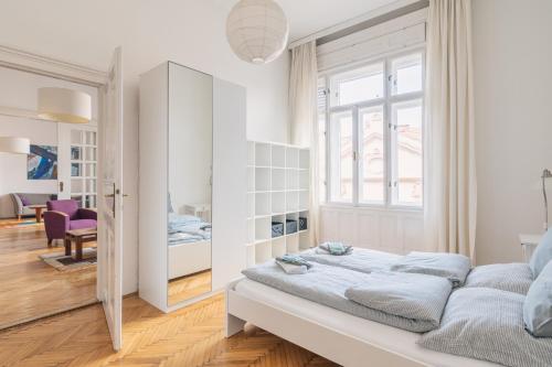 - une chambre blanche avec un lit et une fenêtre dans l'établissement Sunny, Airy, Artsy & Authentic Loft with Balcony, à Budapest